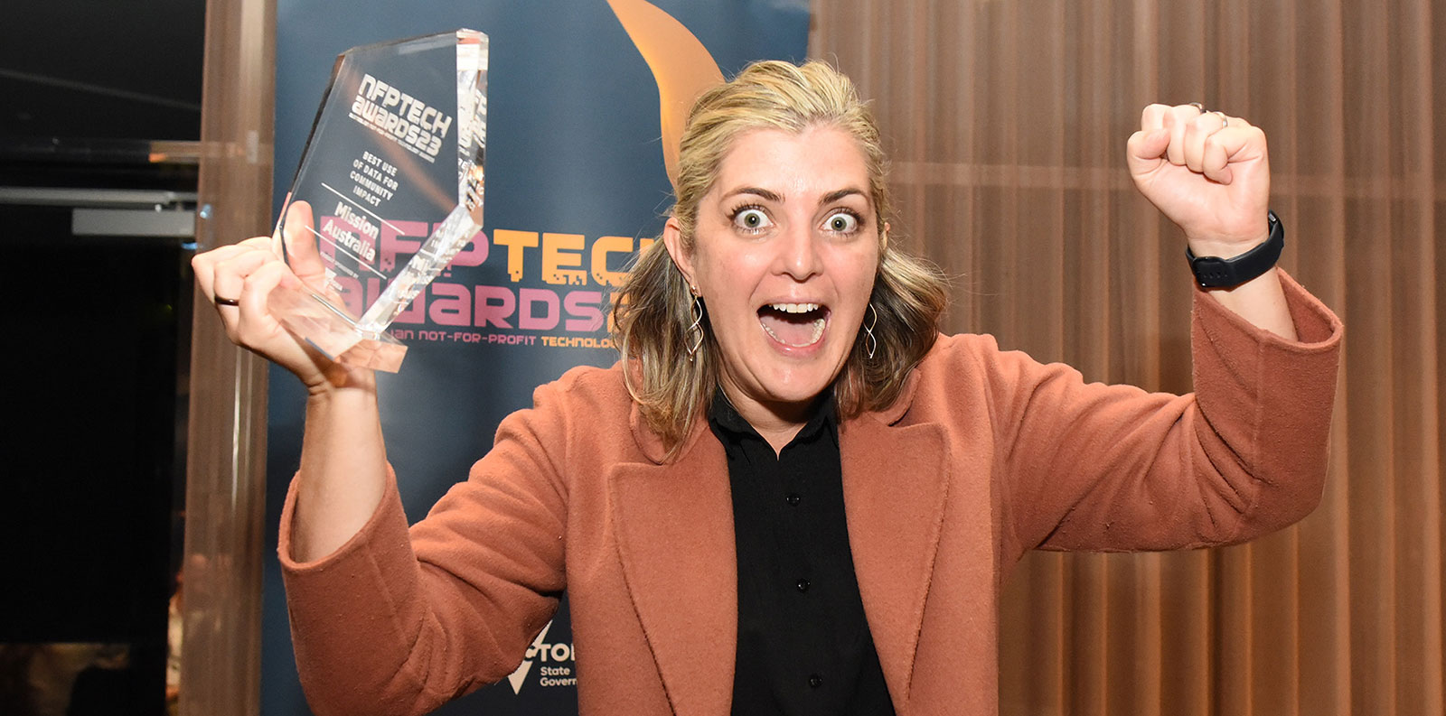Photo of woman holding award and celebrating win