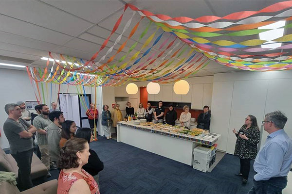 Photo of an office with streamers hung on the ceiling and a group of people